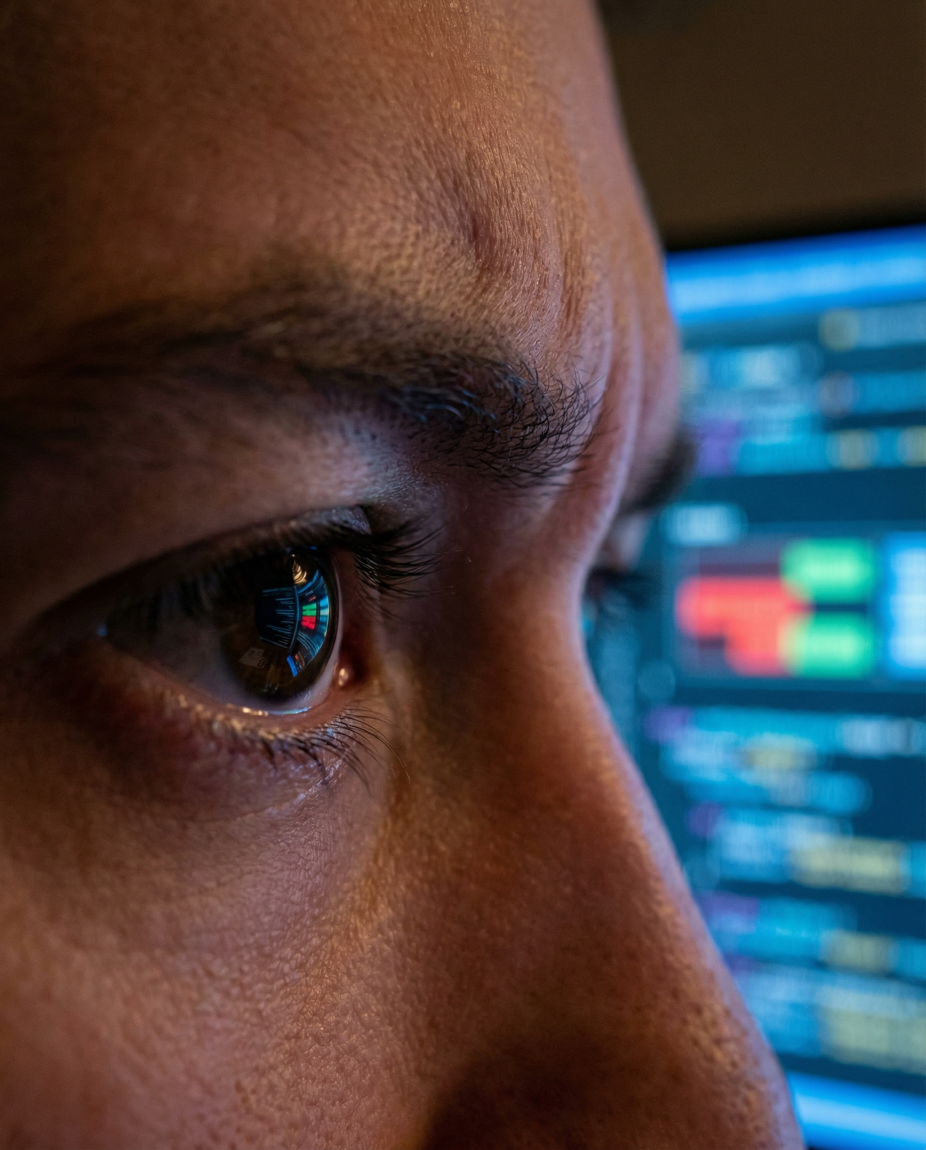 Photorealistic editorial photograph: extreme close-up of computer screen reflecting in someone's concentrated eyes as they review live AI editing suggestions highlighting tone inconsistencies in red a